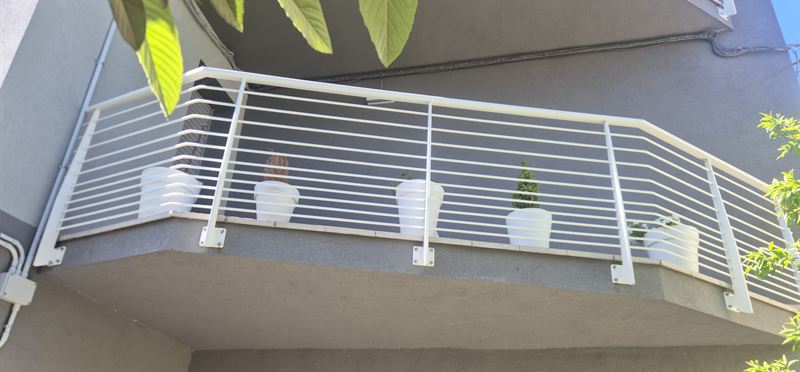 Ringhiera bianca per balcone a correnti orizzontali, fissata sul frontalino